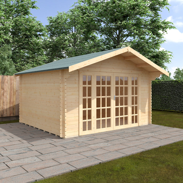Wooden garden log cabin with a green roof on a paved area with grass and trees in the background